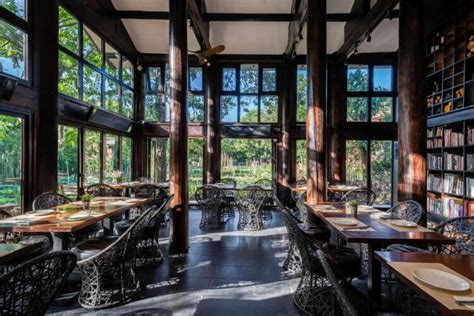 Eetzaal met houten pilaren en uitzicht op het groen